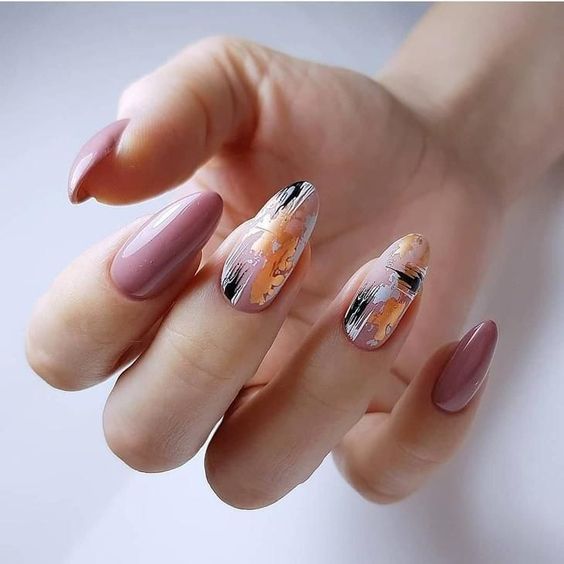 Uñas acrílicas cortas en forma de almendra en rosa palo y dos dedos en naranja, negro y blanco