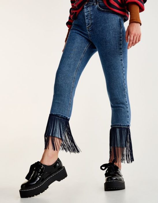 Jeans decorados con flecos bajos en los puños de color negro