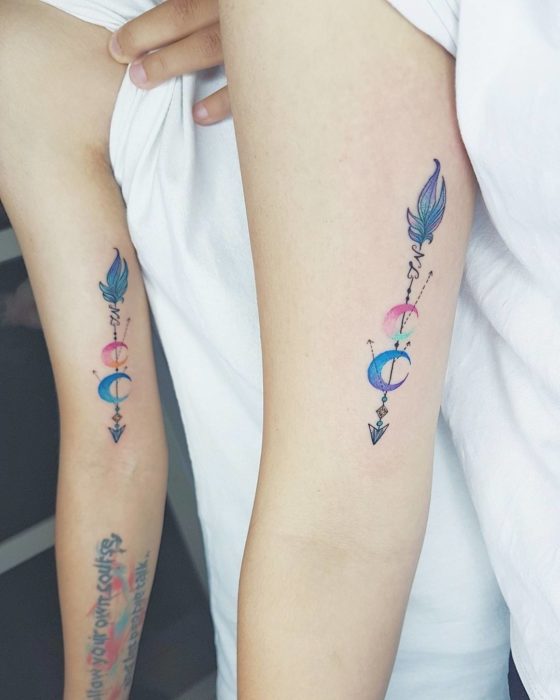 Tatuajes para compartir con tu mejor amiga con diseño de flechas de medias lunas y plumas en tonos azul, morado y rosa