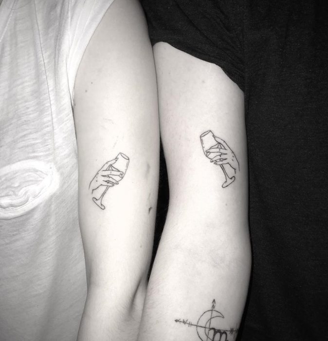 Tatuajes para compartir con tu mejor amiga con diseño de copas de vino chocando entre sí