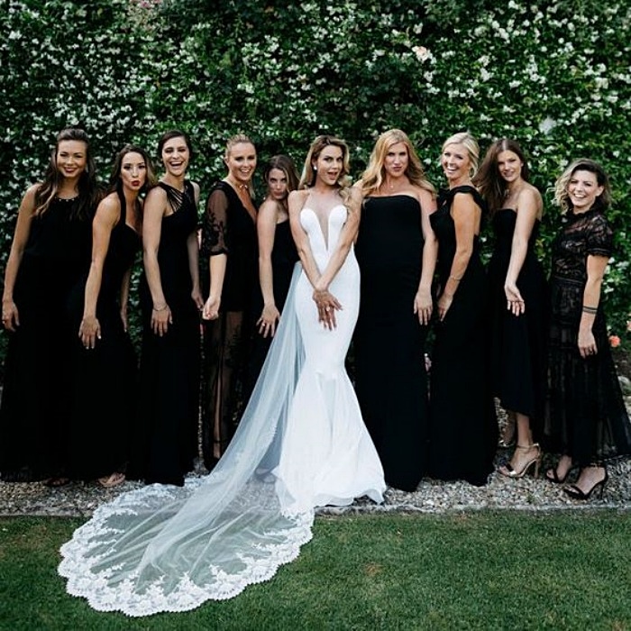 damas de honor posando con la novia, con vestidos de color negro en diseños diferentes