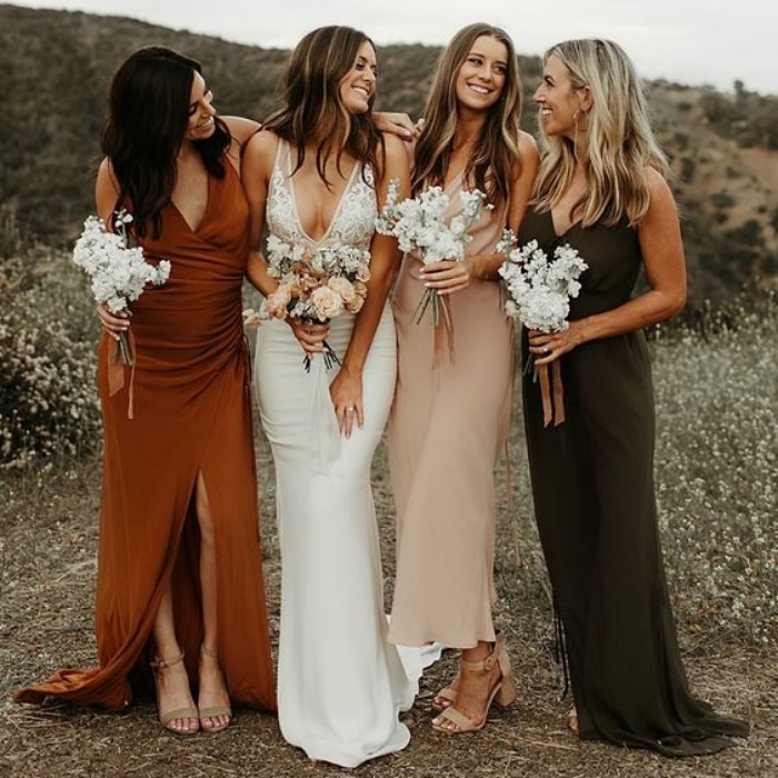 damas de honor con vestidos en diferentes colores, anaranjado, beige y gris oscuro