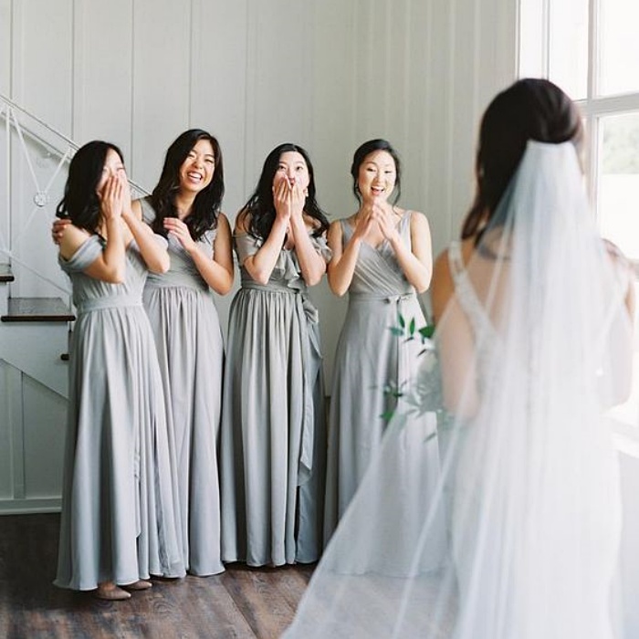 damas de honor viendo a la novia, usando vestidos de color gris pastel