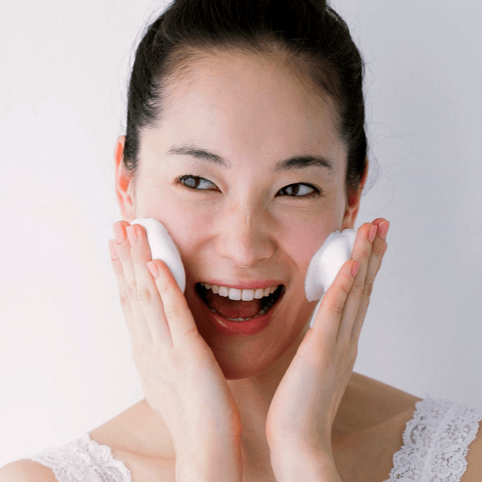 chica usando un limpiador facial