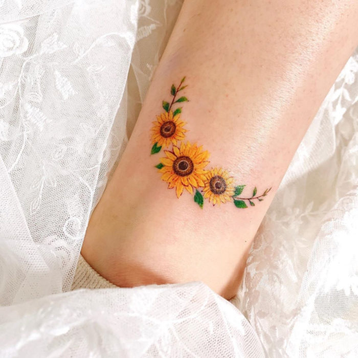 Tatuaje de corona de girasoles pequeños en el brazo