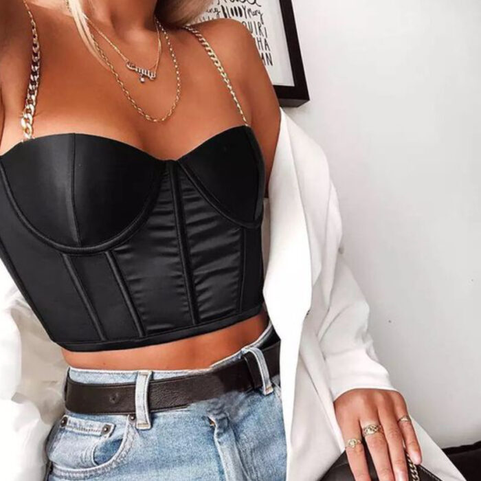 Chica usando corsé de color negro con tirantes de cadenas