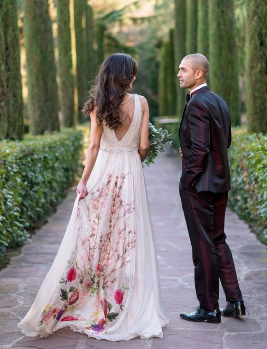 Novia con vestido blanco con la parte trasera decorada con flores