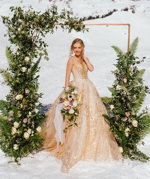 Novia rubia con vestido dorado en la nieve