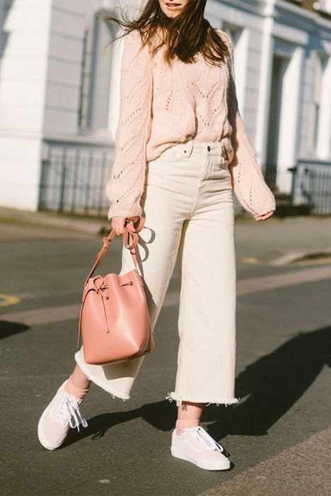 Chica usando jeans rectos con suéter rosa y bucket bag rosa