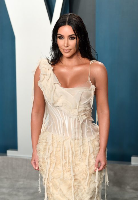 Kim Kardashian usando un vestido de color beige mientras posa para las cámaras del after party de la revista Vanity Fair