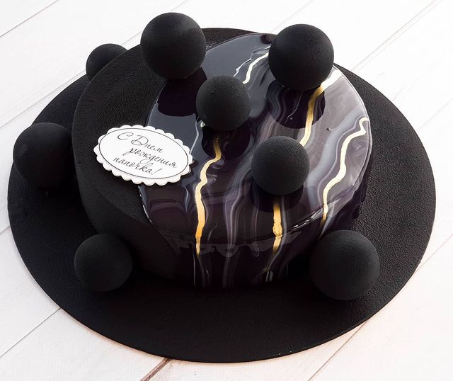 Pastel de un piso con betún negro y dorado de sabor chocolate