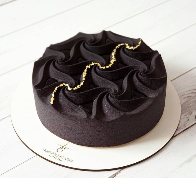 Pastel de un piso con betún negro y decorado en dorado
