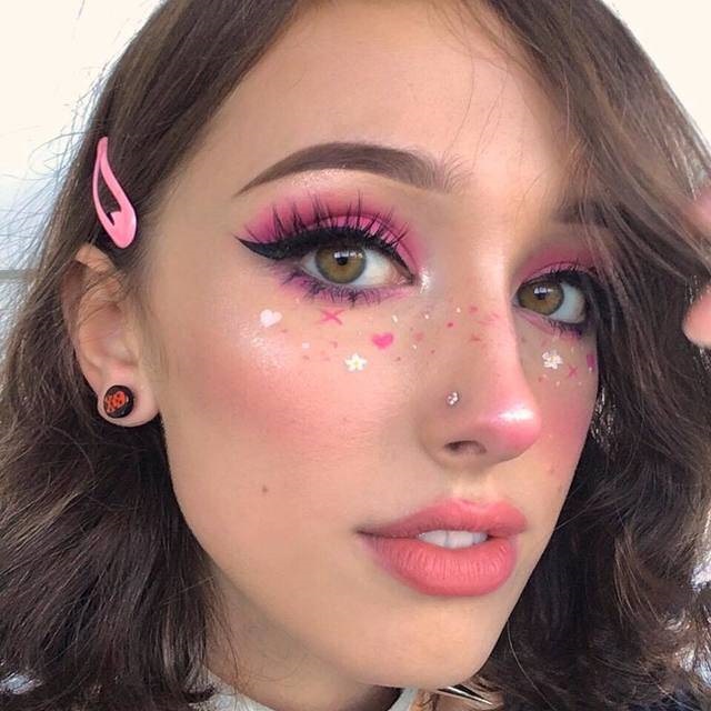Chica con maquillaje en rosa fucsia y delineado de pecas en corazones