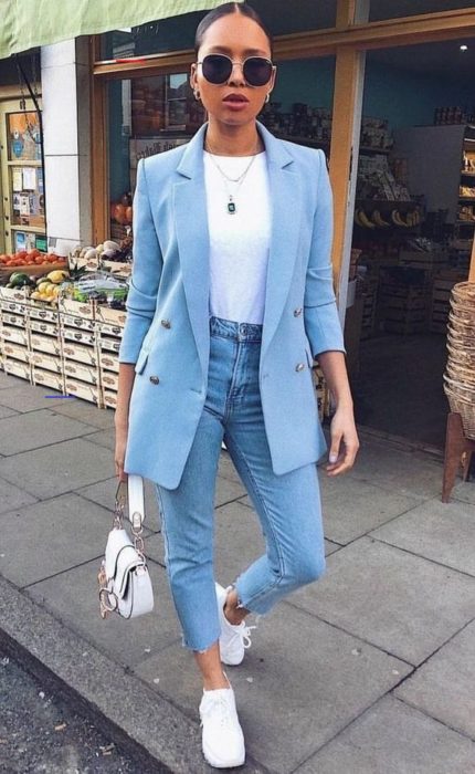 Chica con jeans denim, blusa blanca, blazer azul cielo y tenis blancos