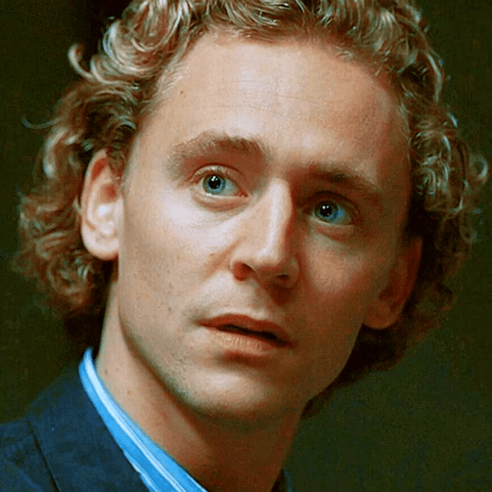 tom hiddleston rubio con camisa azul y abrigo azul marino