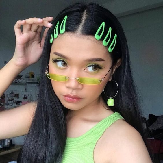 Chica asiática con cabello largo, lacio y negro con broches verde neón en la parte delantera