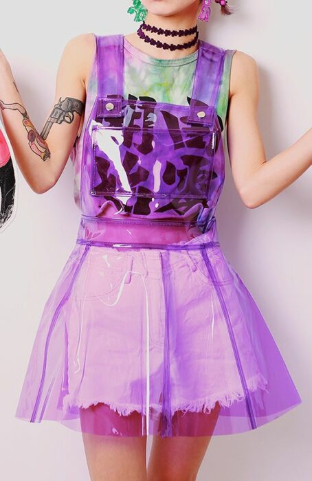Chica posando de pie con un vestido de plástico transparente color morado
