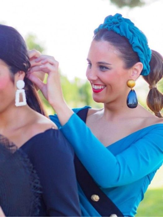 Chica usa vestido, aretes y diadema color azul con cola de peinado