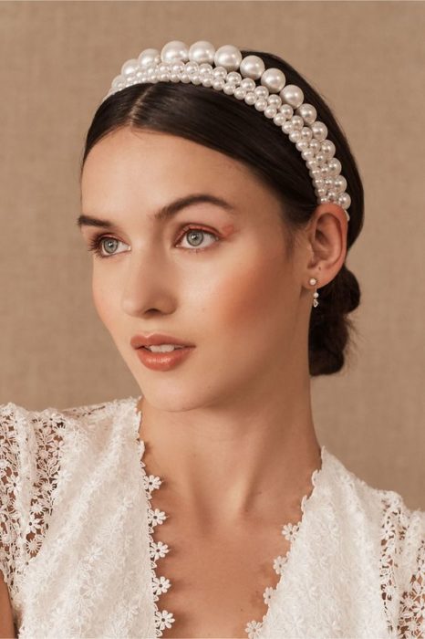 Chica con recogido bajo pulido y diadema de perlas