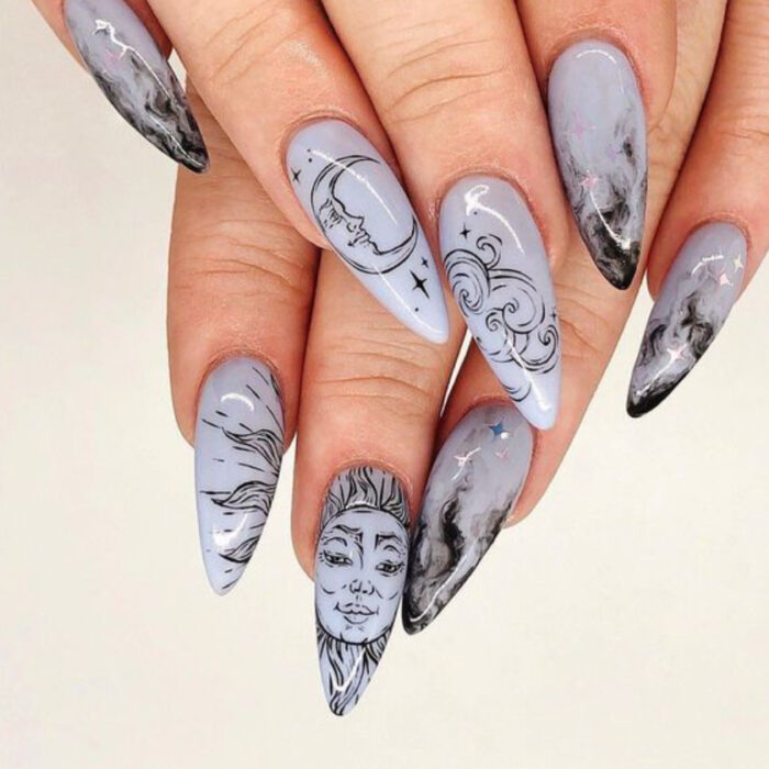 Manicura con diseño de luna y sol en color negro con base azul grisáceo