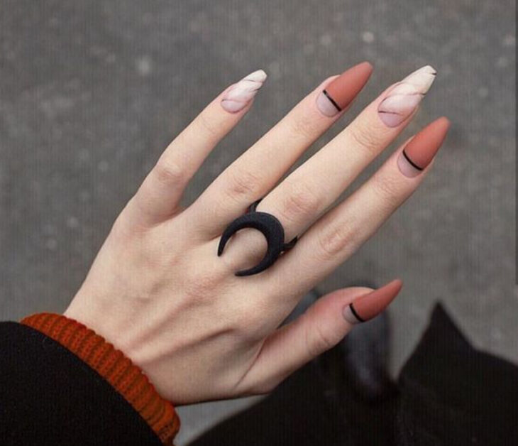 Manicura con diseño de mármol, líneas y colores naranja quemado y nudes