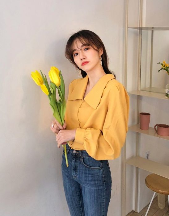 Chica asiática con blusa amarilla con cuello bobo