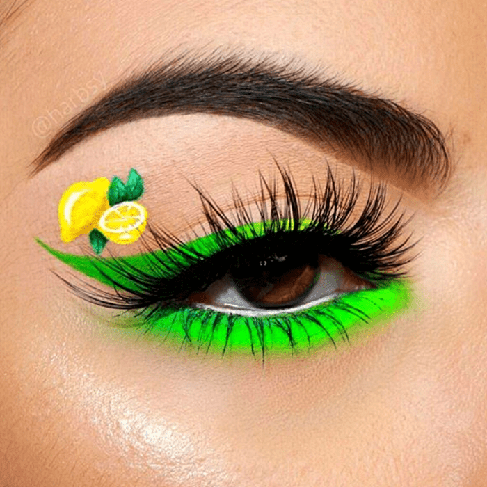 maquillaje verde con delineado verde neón y dibujo de limón amarillo