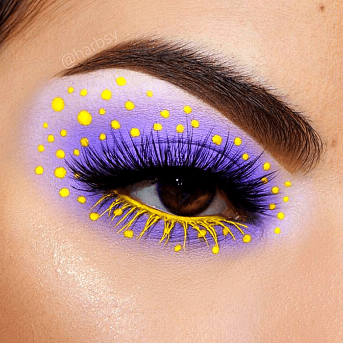 maquillaje morado con lila y puntos amarillos, delineado amarillo con rímel negro y amarillo