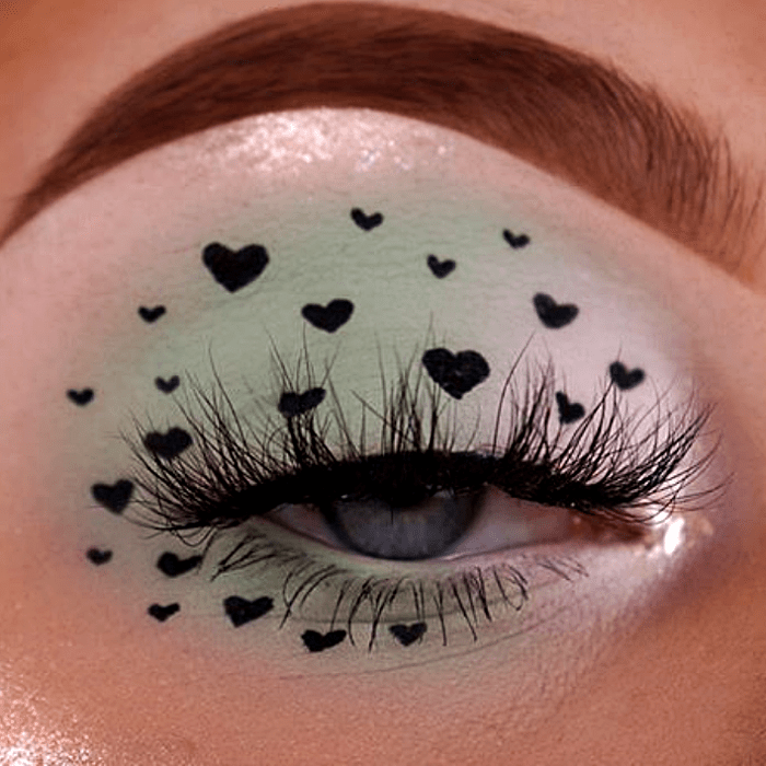 maquillaje color menta con corazones negros y sombreado blanco