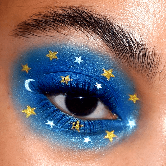 maquillaje de ojos azul con sombreado intenso y estrellitas doradas y plateadas
