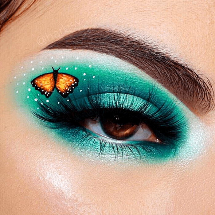 maquillaje de ojos sombreado verde con blanco y dibujo de mariposa amarilla con naranja