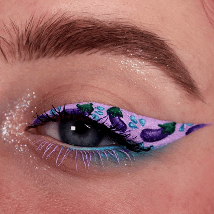 maquillaje de ojos morado con emojis de berenjena y delineado rosa