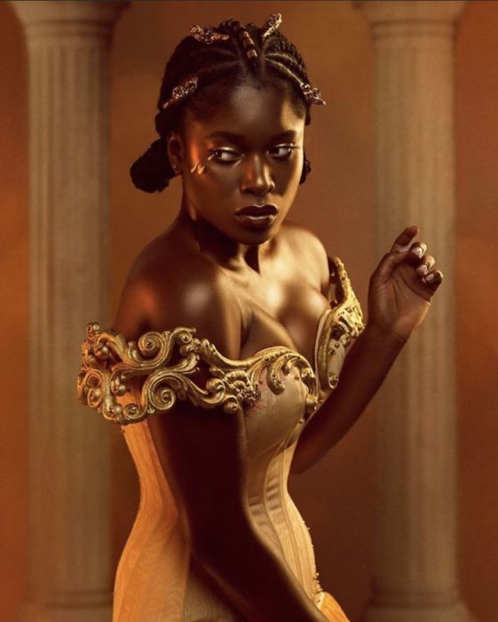 Chica negra con vestido sin hombros y color amarillo