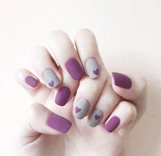 manicura en color uva y gris con detalles de corazones