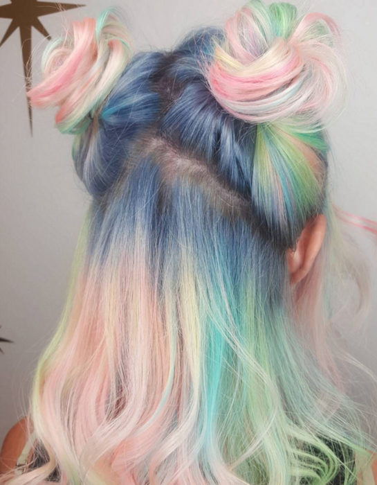 Chica con cabello a los hombros, lacio y teñido de colores arcoíris pastel, azul, verde, amarillo, rosa y morado, peinado kawaii con dos chongos estilo Sailor Moon