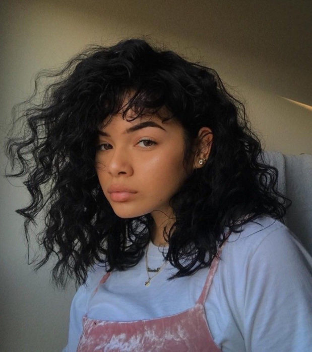 Looks aesthetic con cabello corto color negro, rizado y despeinado, mujer morena