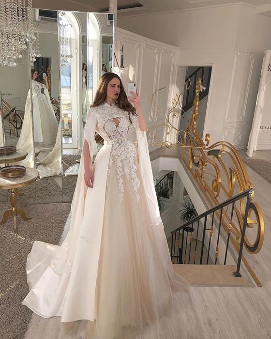 Chica con vestido de novia diseñado por Marionela con mangas amplias y abiertas