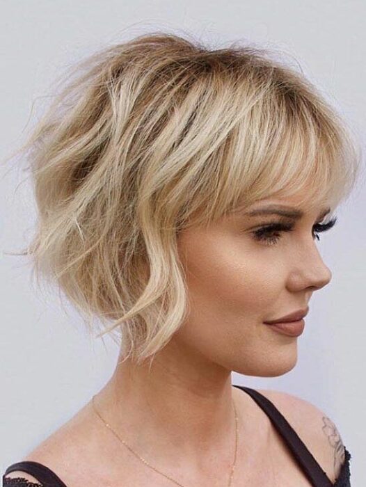 Mujer rubia de perfil con melena muy corta ligeramente rizada