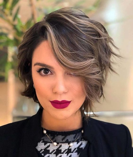 Mujer blanca de cabello corto oscuro con efectos rubios