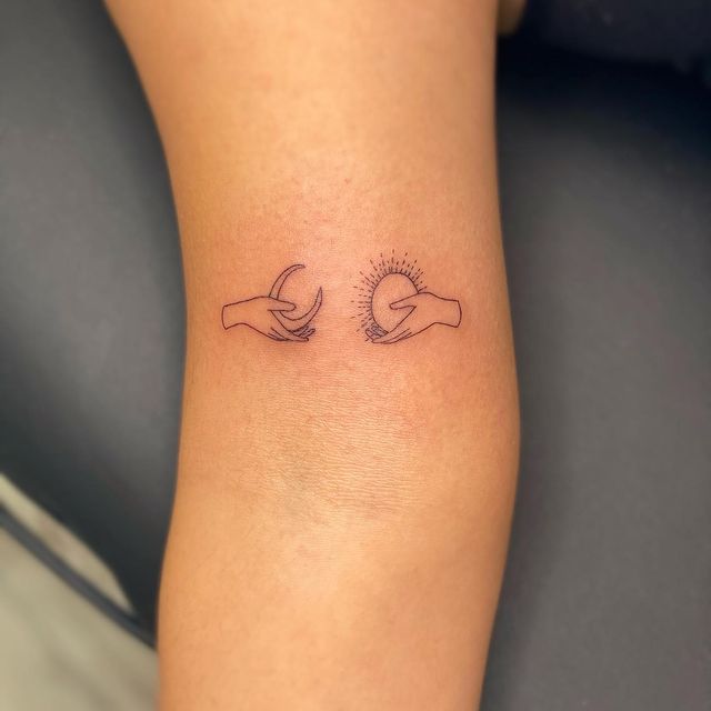 Tatuaje en el brazo de manos con luna y sol