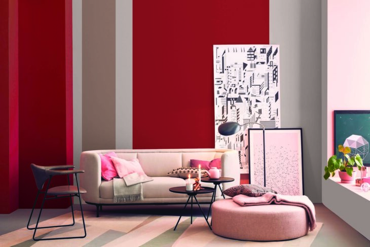 Pared pintada en tonos neutros con acentos en color rojo en una sala con tonos pastel estilo minimalista.