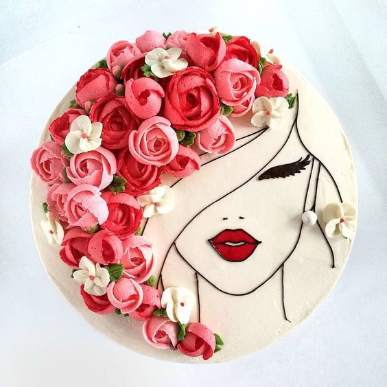 Pastel con cobertura blanca decorado con flores de betún rosa y rojo