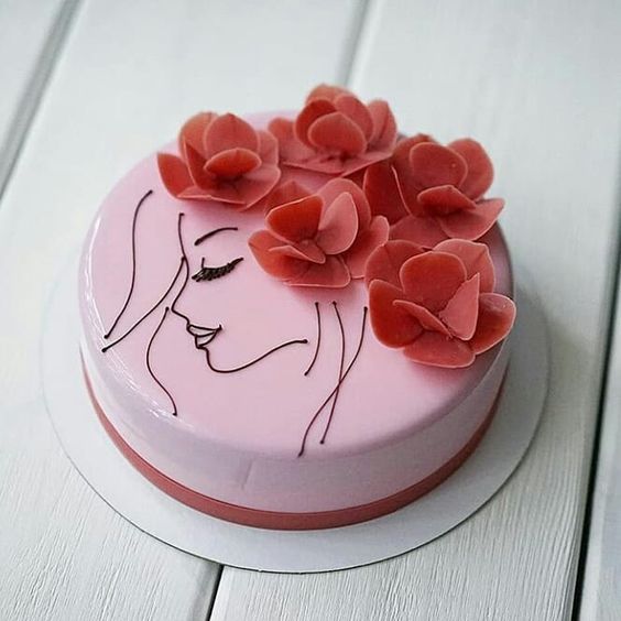 Pastel de fresa decorado con la silueta de una chica en chocolate y flores de fondant