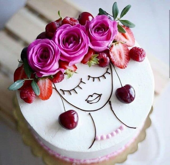 Pastel de un piso con cobertura blanca adornado con cerezas, fresas y flores naturales