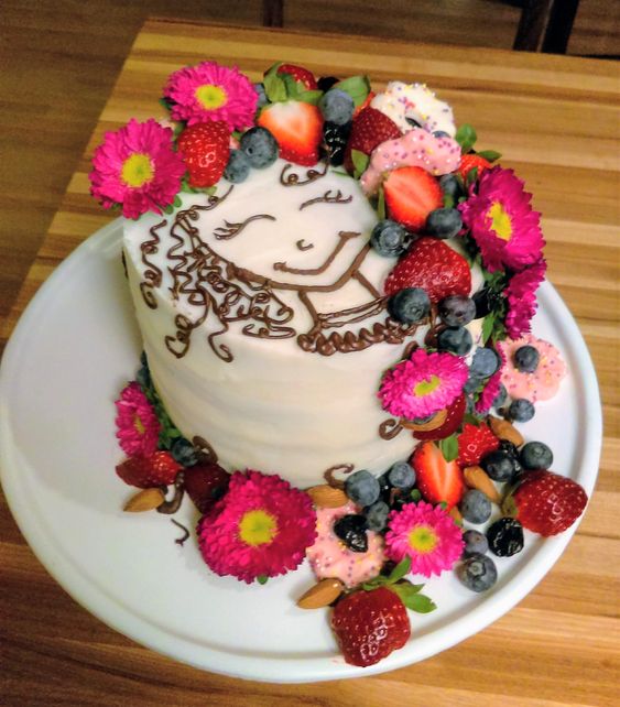 Pastel de vainilla decorado con margaritas, fresas y arándanos