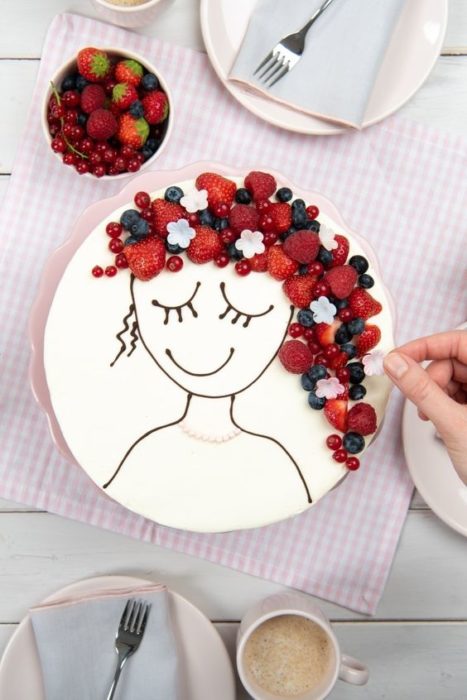 Pastel de cobertura de vainilla adornado con frambuesas, arándanos y fresas
