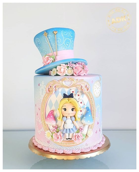 Pastel en tonos azules con relleno de vainilla inspirado en Alicia en el país de las maravillas