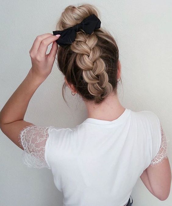 Chica con trenza inversa y un moño negro