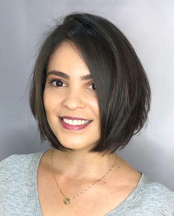 Mujer morena con melena corta y oscura con camiseta gris
