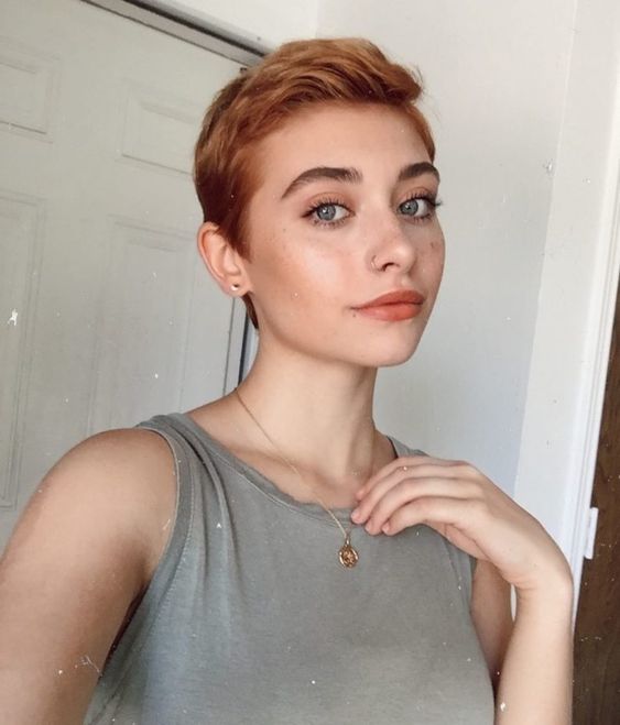 Mujer delgada con corte de cabello pixie color naranja